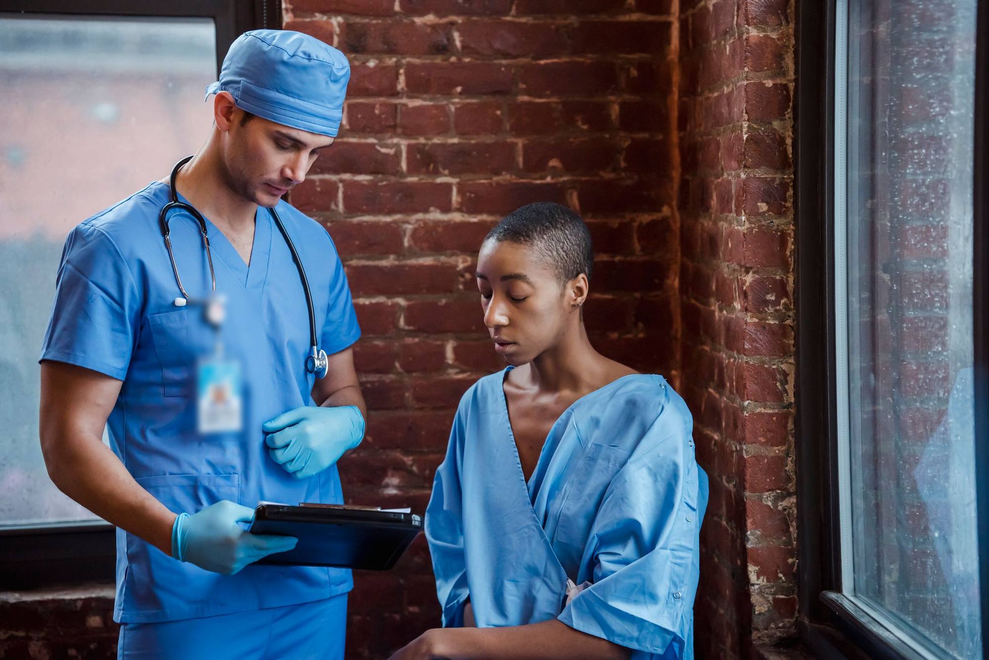 A nurse goes through a patient's results with her on a tablet